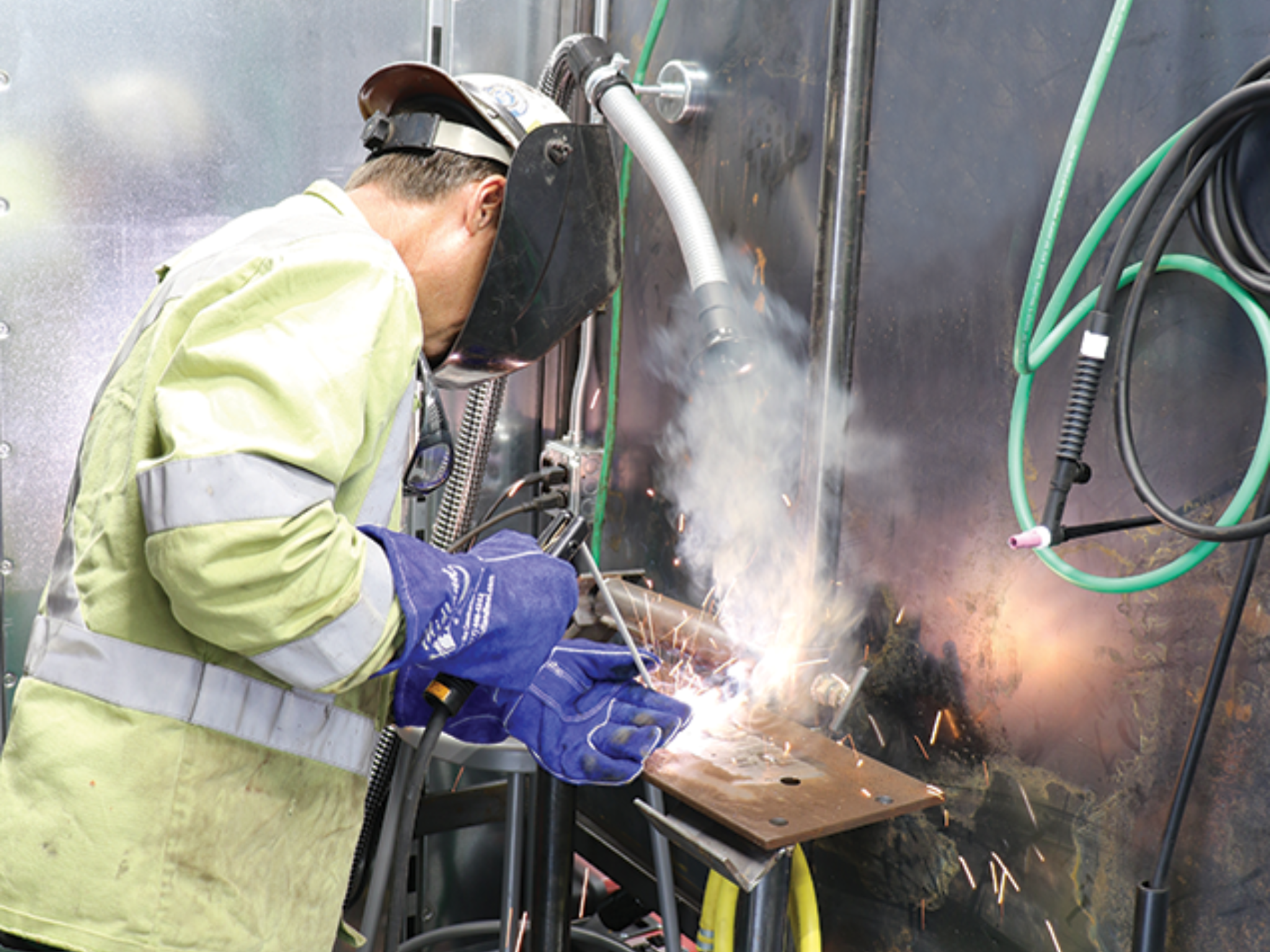 welder working inside weld test trailer